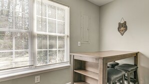 A room with a window, a wall-mounted light switch, and a wooden table with two chairs. - 2 Mi to Lenovo Center: Dog-friendly Getaway (Raleigh)