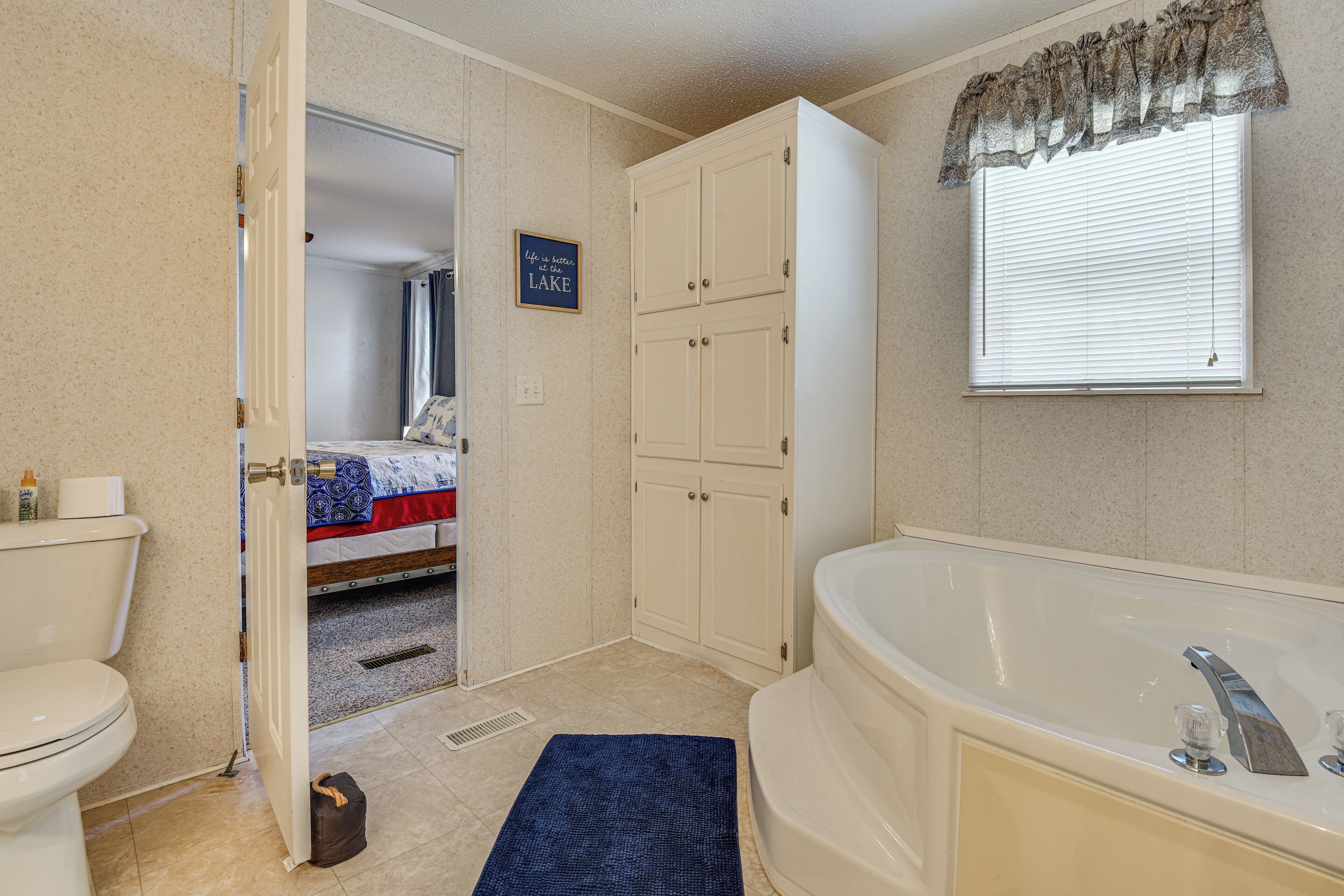 A bathroom with a bathtub, toilet, and a shower area.