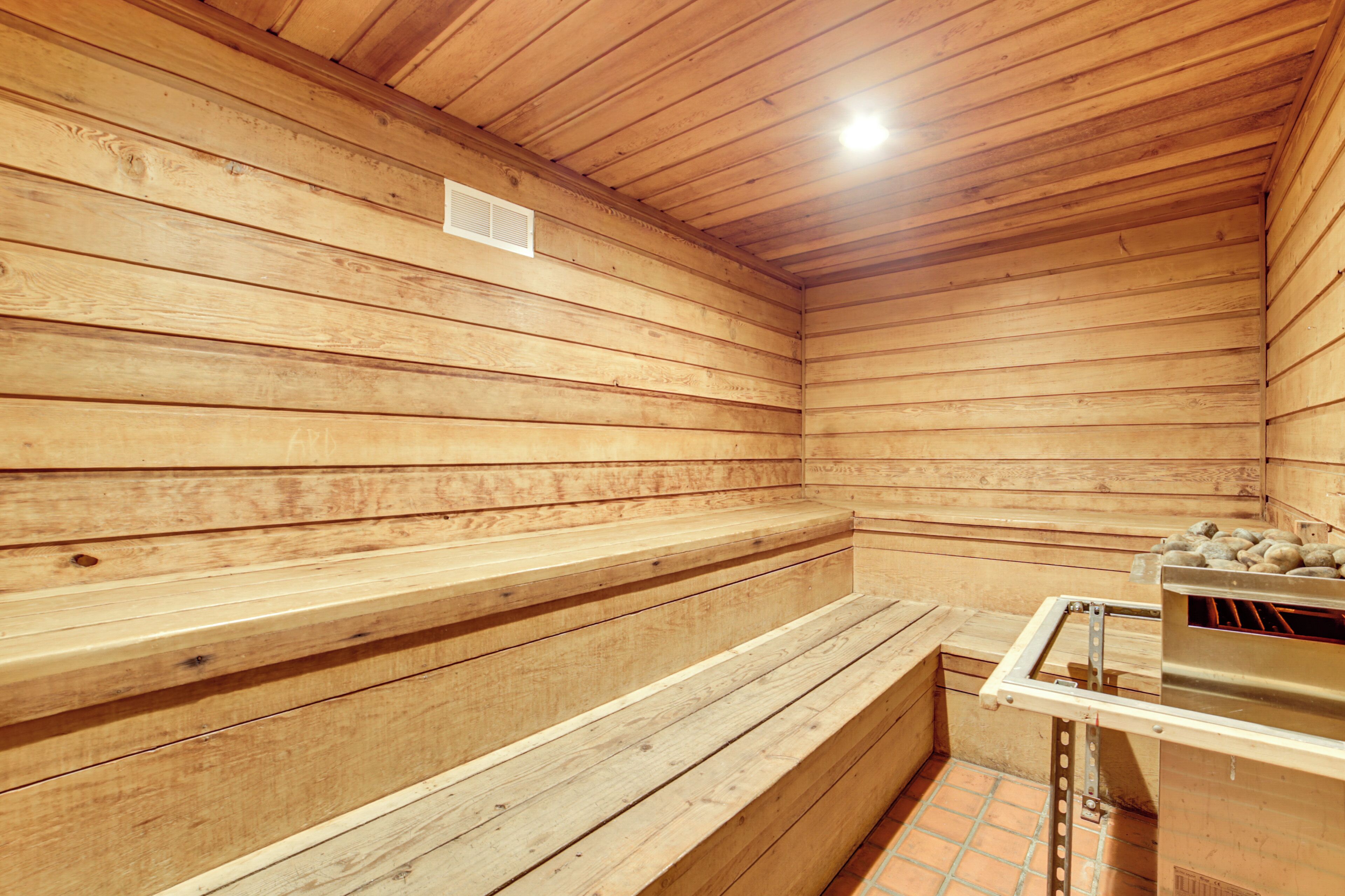 Una sauna con panche in legno e un generatore di vapore.