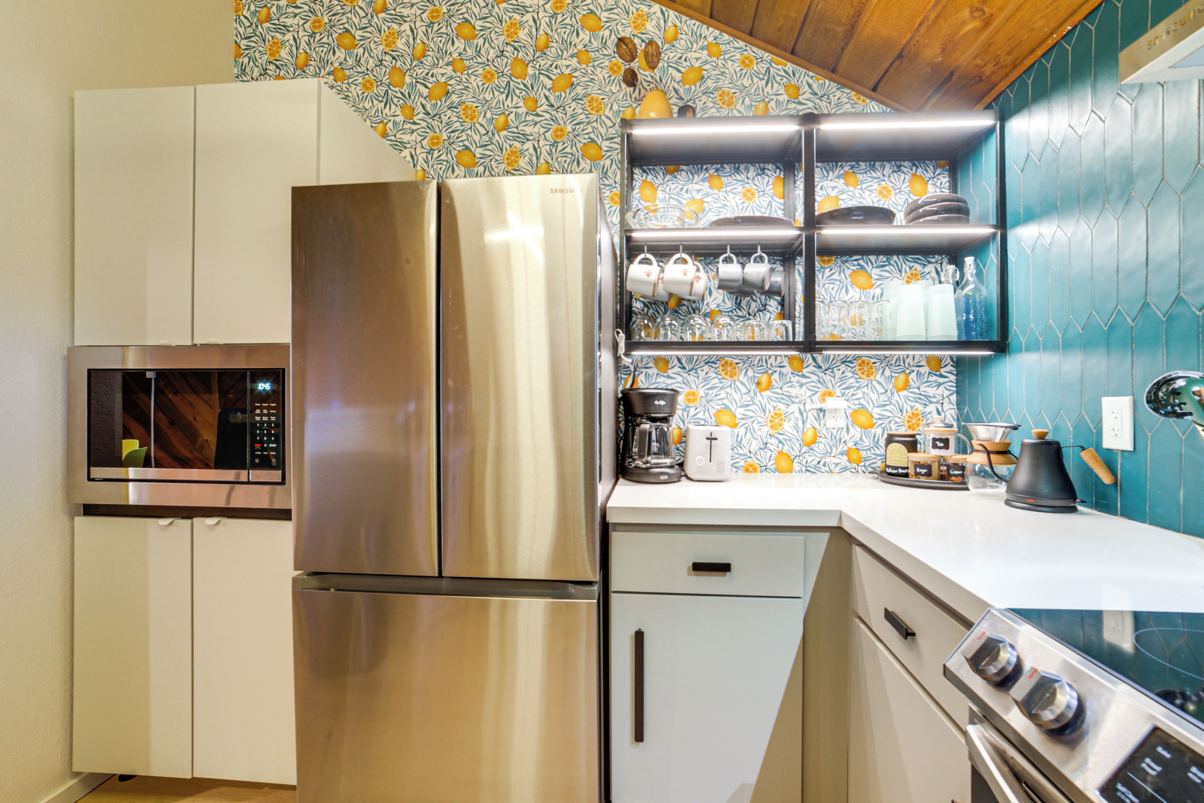 A modern kitchen with stainless steel appliances, a microwave, a coffee maker, and a toaster.