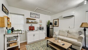 A compact living space with a kitchenette, a sofa, a coffee table, and a patterned rug. - Golf, Shop & Unwind: Couple's Retreat in Naples! (Naples)