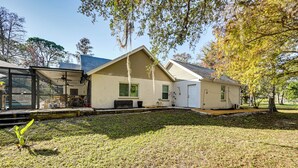 A single-story house with a covered porch, a small front yard, and a tree with autumn leaves. - Golf, Shop & Unwind: Couple's Retreat in Naples! (Naples)