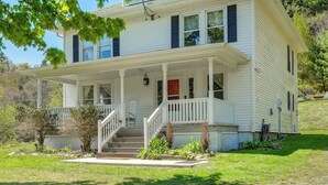 A two-story house with a front porch, a red door, and a staircase leading to the entrance. - 3 Mi to Crab Tree Falls! Mtn-view Family Retreat (Montebello)