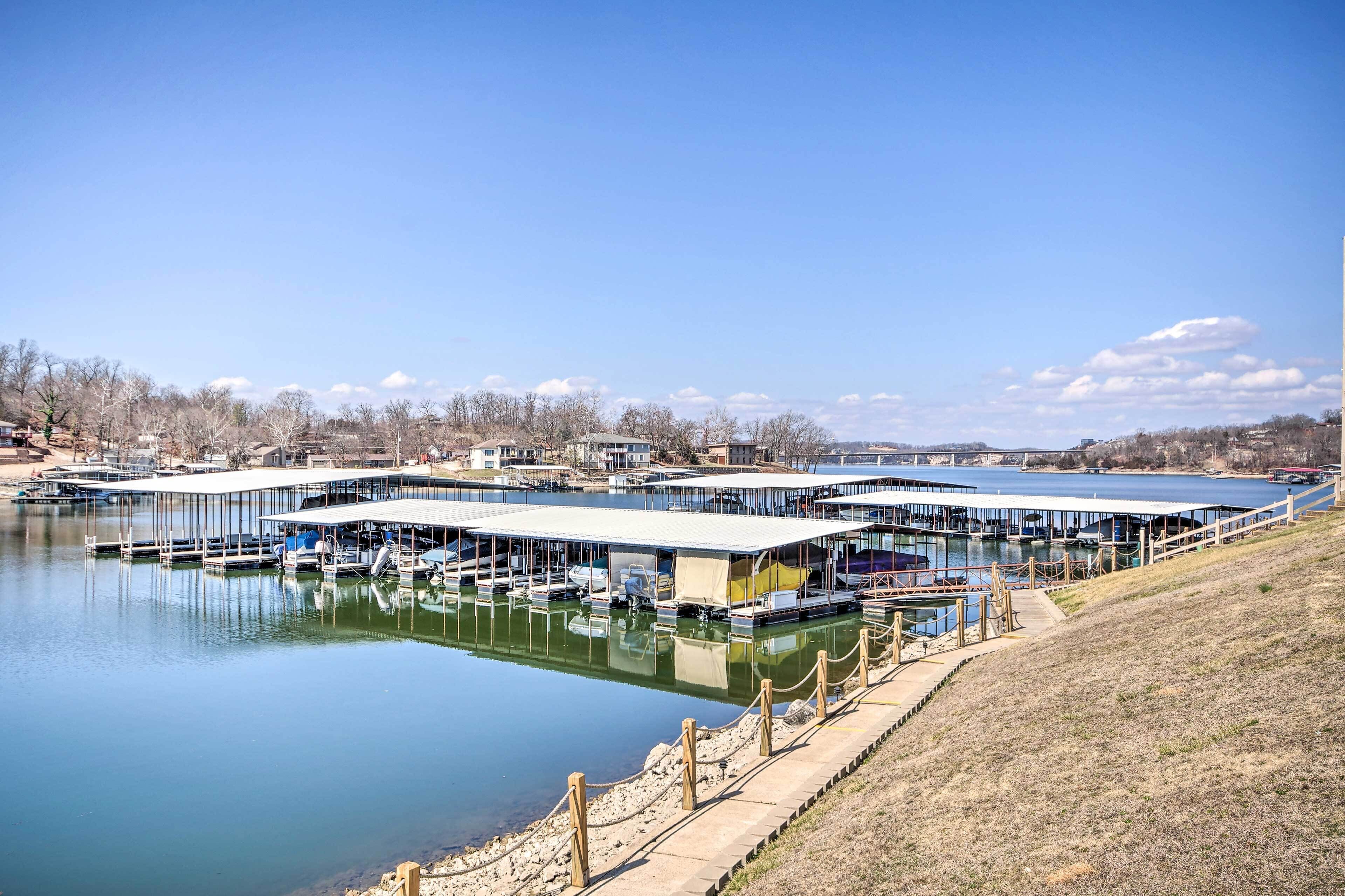 Un port de plaisance avec des quais et des bateaux, une rampe d’accès à l’eau abritée et un ciel dégagé.