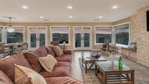 A spacious living area with a leather sofa, a wooden coffee table, and a view through large glass doors. - Private Paso Robles Wine Estate w/ Pool, Fire Pit & Vineyard Views (Templeton)