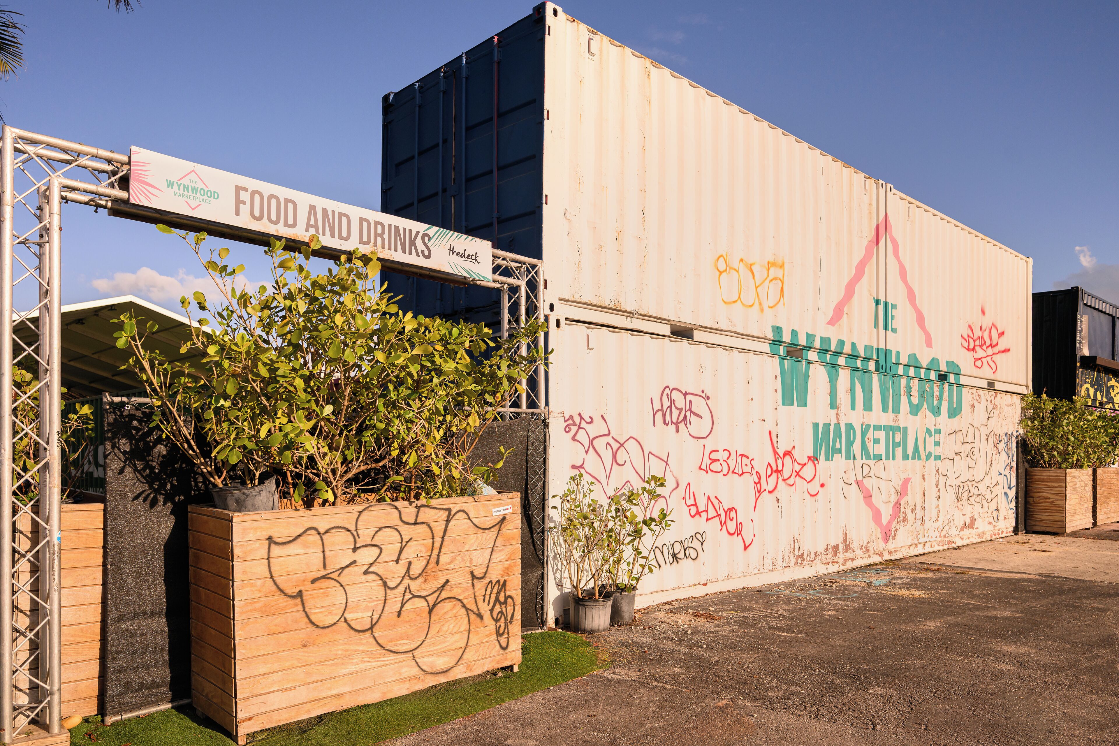 Un grand conteneur maritime, couvert de graffitis, avec une enseigne indiquant « Wynwood Marketplace ».
