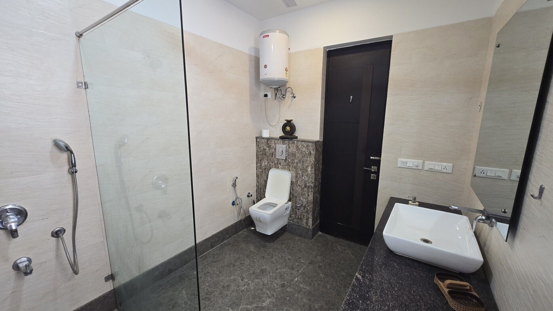 Een badkamer met een douchecabine, toilet en wastafel.