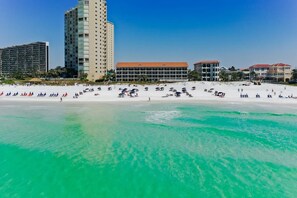 Ein Strand mit einem Hotel im Hintergrund.