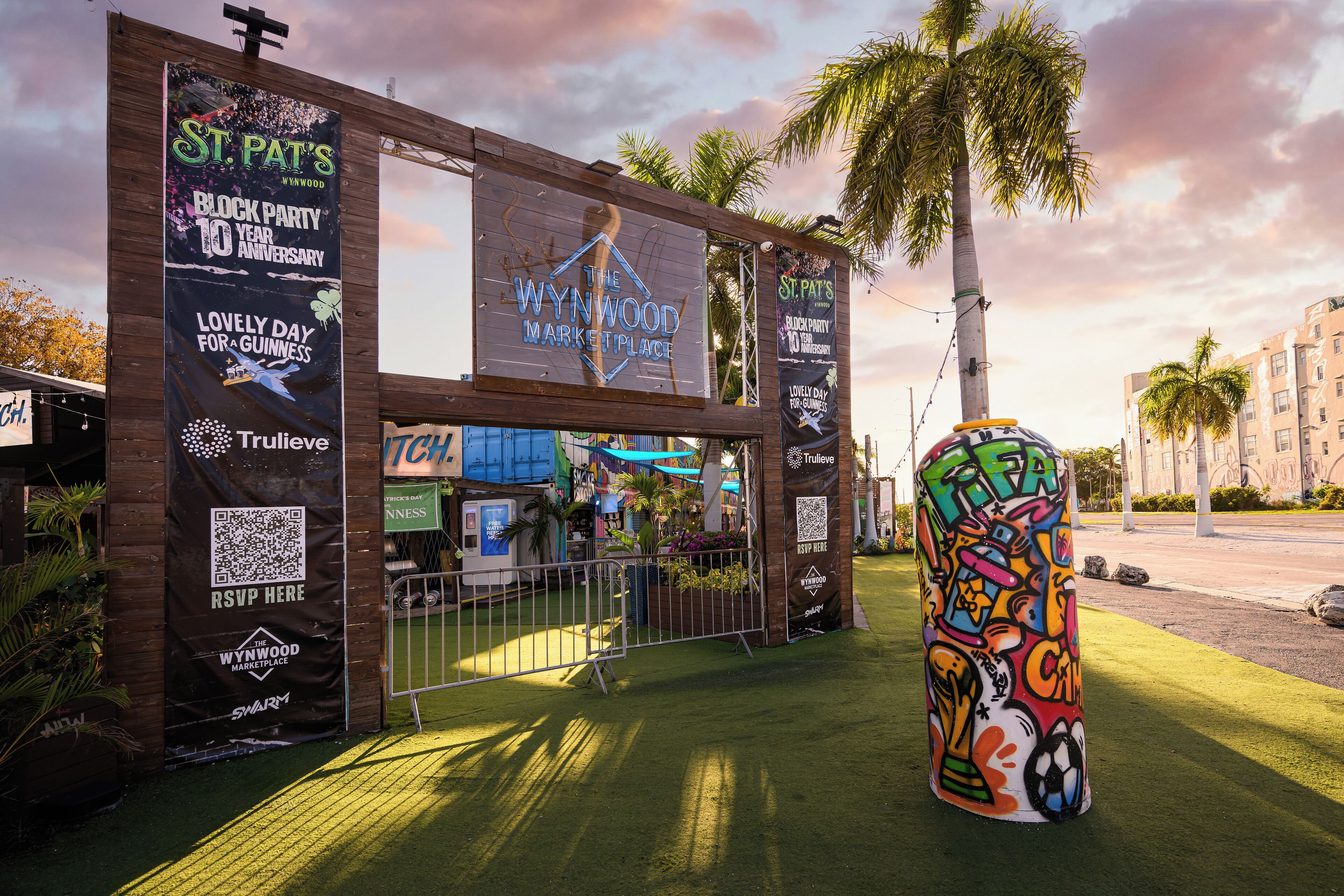Een houten constructie met banners die de St. Pat's Block Party en The Wynwood Marketplace promoten.