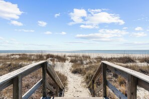 A wooden boardwalk leading to a beach with sand dunes and a clear blue sky. - Easy beach access and coveted Seabrook amenities (Seabrook Island)