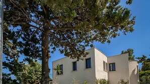 Plage Concept -hotellin kyltti, jossa on kivimuuri ja metallinen portti.