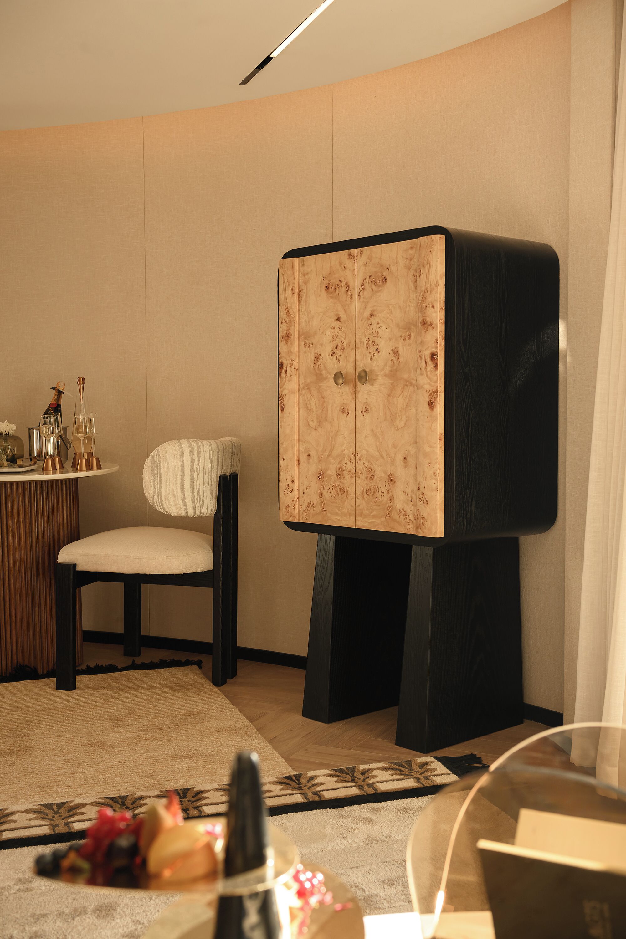 Una stanza moderna con un mobile d'arredo particolare, un tavolo da pranzo con un vaso e una sedia.