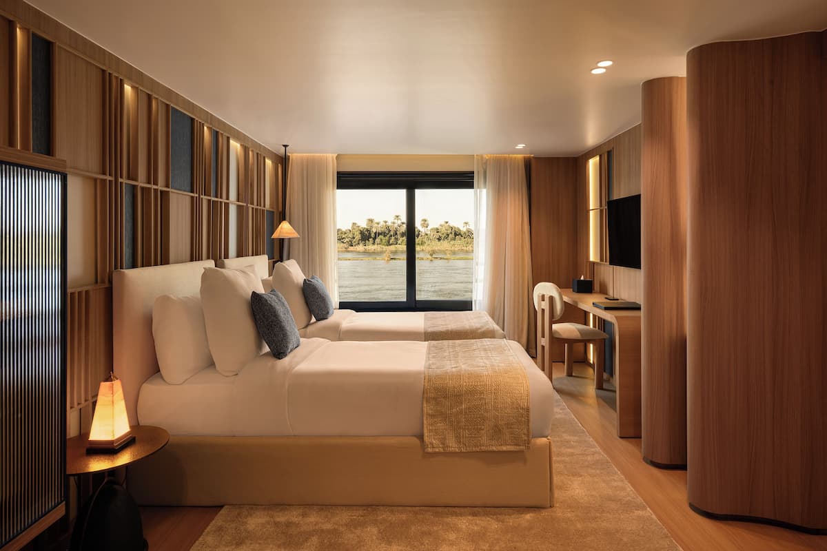 Ein modernes Hotelzimmer mit einem großen Bett, einem Schreibtisch und Blick auf ein Gewässer.