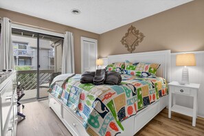 A bedroom with a large bed, a balcony, and a piano. - Ocean View Condominium 2 Bedroom Condo (Myrtle Beach)
