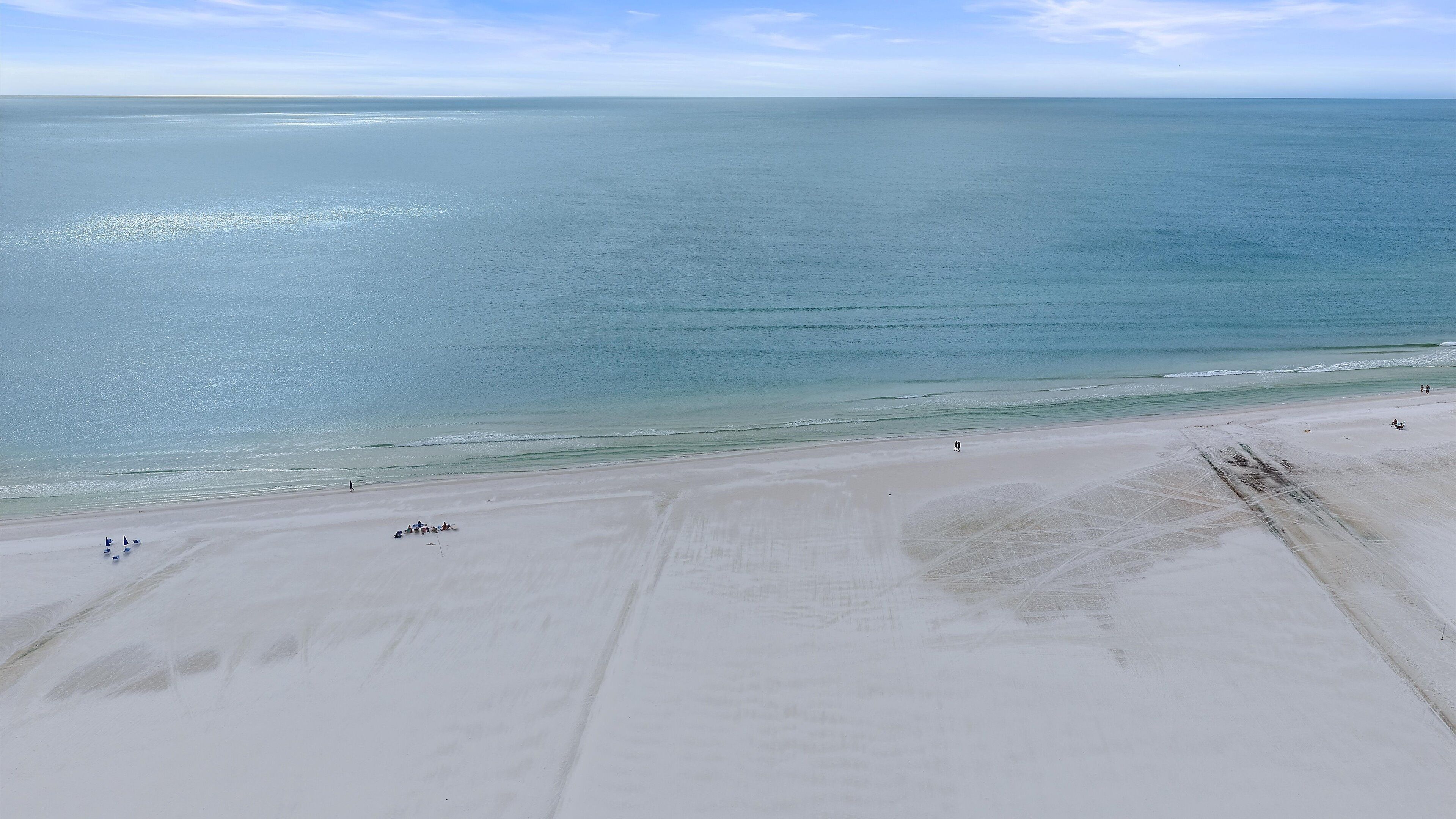 A wide beach with a clear view of the ocean.