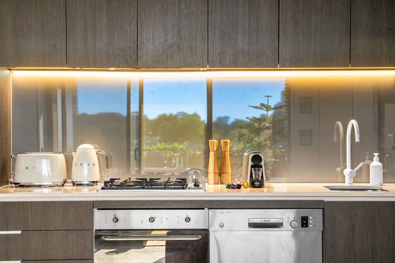 A modern kitchen with a built-in dishwasher, a stove, and a sink.