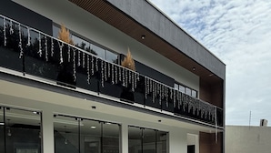 Un edificio moderno con piscina, puertas de vidrio amplias y terraza de madera.