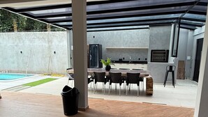 Un espacio habitable de concepto abierto con comedor, cocina y vistas a una piscina.