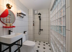 A modern bathroom with a white sink, toilet, and shower. There is a red-framed mirror above the sink and a glass shower enclosure. - Little An Home (Ho Chi Minh City)