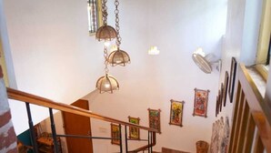 Una escalera con barandilla de madera y balaustres metálicos, que desciende a un nivel inferior.
