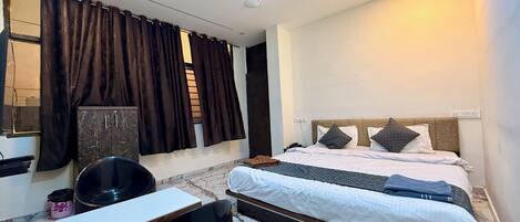 A modern bedroom with a bed, a desk, and a chair.