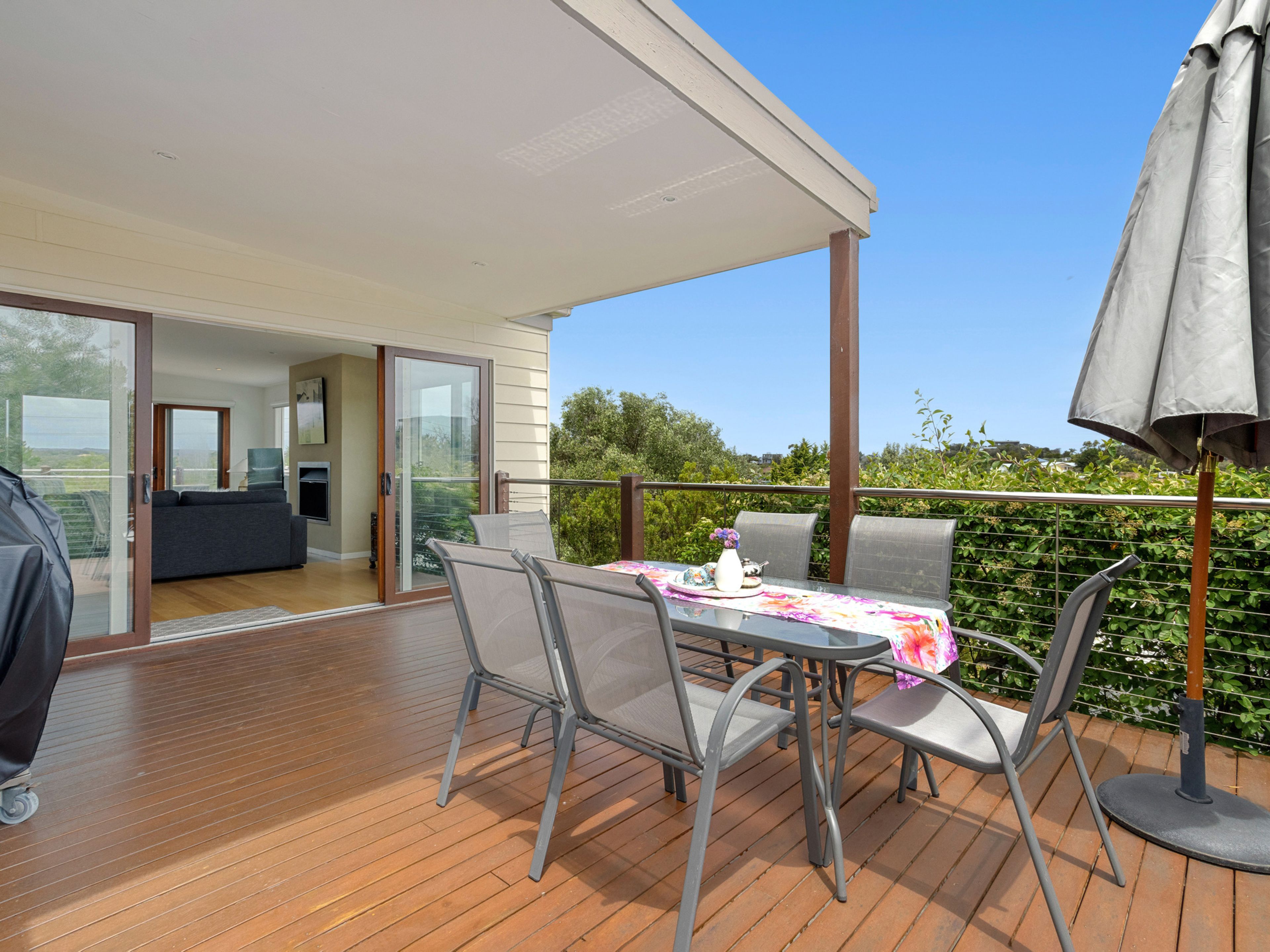 Eine Terrasse im Freien mit Tisch, Stühlen und einem Grill.