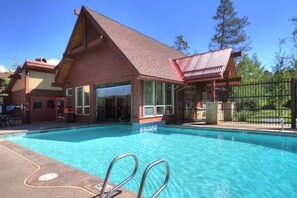 A building with a pool, a covered area, and a fenced outdoor space. - Ski-in, Walk to Lift & Town, Hot Tubs & Heated Pool, Kid-Friendly (Breckenridge)