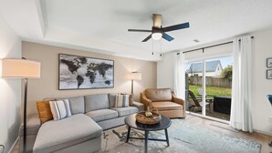 A living room with a sofa, armchairs, a coffee table, and a world map artwork. - Private Parking, Fire Ring, King Beds - Near Ark! (Dry Ridge)