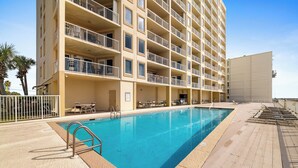A hotel with a swimming pool, multiple balconies, and outdoor seating areas. - Boardwalk 886 by Liquid Life (Gulf Shores)