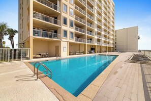 A hotel with a swimming pool, multiple balconies, and outdoor seating areas. - Boardwalk 886 by Liquid Life (Gulf Shores)
