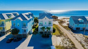 A beachfront property with multiple two-story buildings, each featuring balconies and a direct view of the ocean. - Beachfront | Pet Friendly | Shared Pool, Elevator (Fort Morgan)