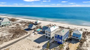 Una propiedad costera con varias construcciones, piscina y vista al mar.