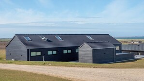 A modern building with a sloped roof, large windows, and skylights. - 5 Star Holiday Home in Lemvig (Lemvig)