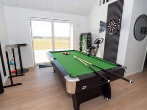 A pool table with billiard balls, a foosball table, a dartboard, and a window with a view. - 5 Star Holiday Home in Lemvig (Lemvig)
