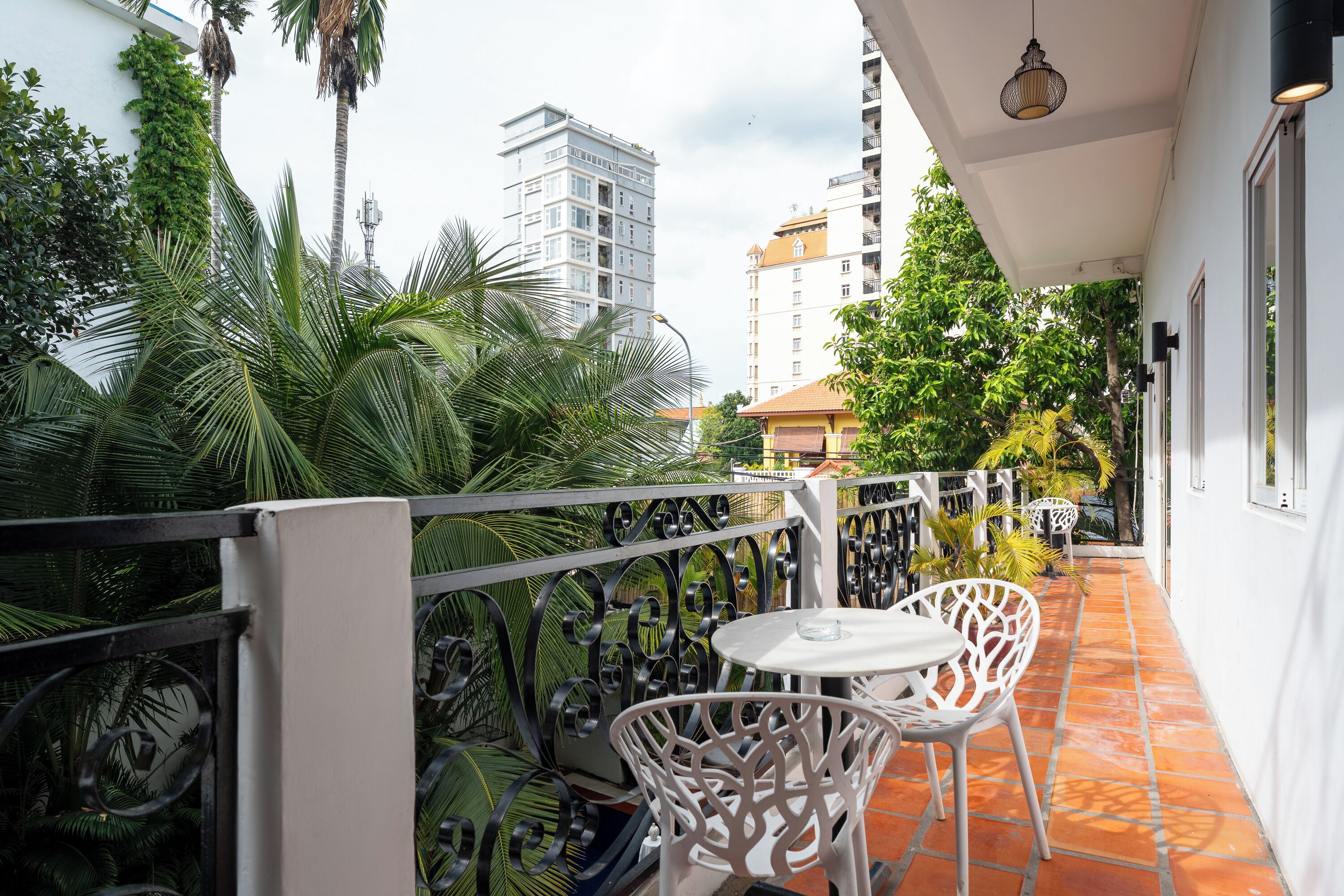 A balcony with a white railing, two white chairs, and a small table.