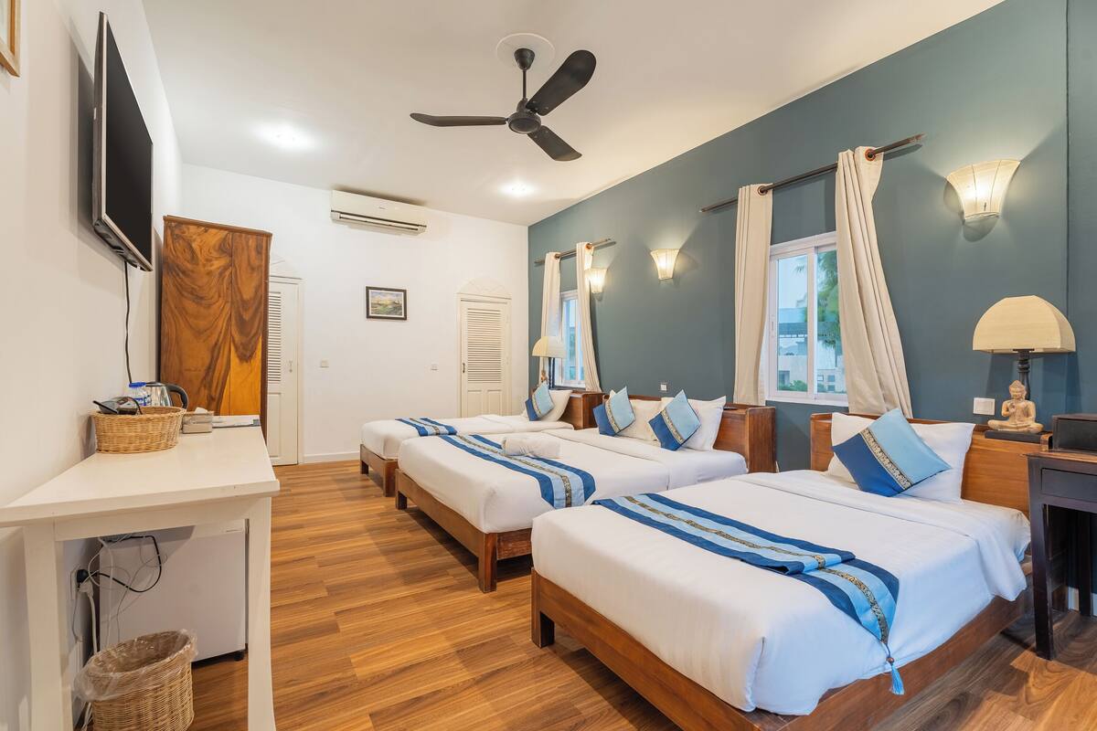 Deluxe Triple Room, Pool View | Minibar, in-room safe, desk, laptop workspace