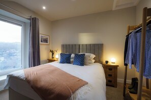 A hotel room with a large bed, a view through a window, a bedside table with a lamp, and a wooden wardrobe. - Fell View Residences , Lakes Escape by LetMeStay (Ambleside)