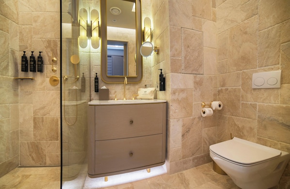 A bathroom with a glass shower enclosure, a vanity with a gold faucet, and a toilet. - Cunda Callisto Hotel & Spa (Adult Only, 12+) (Ayvalik)