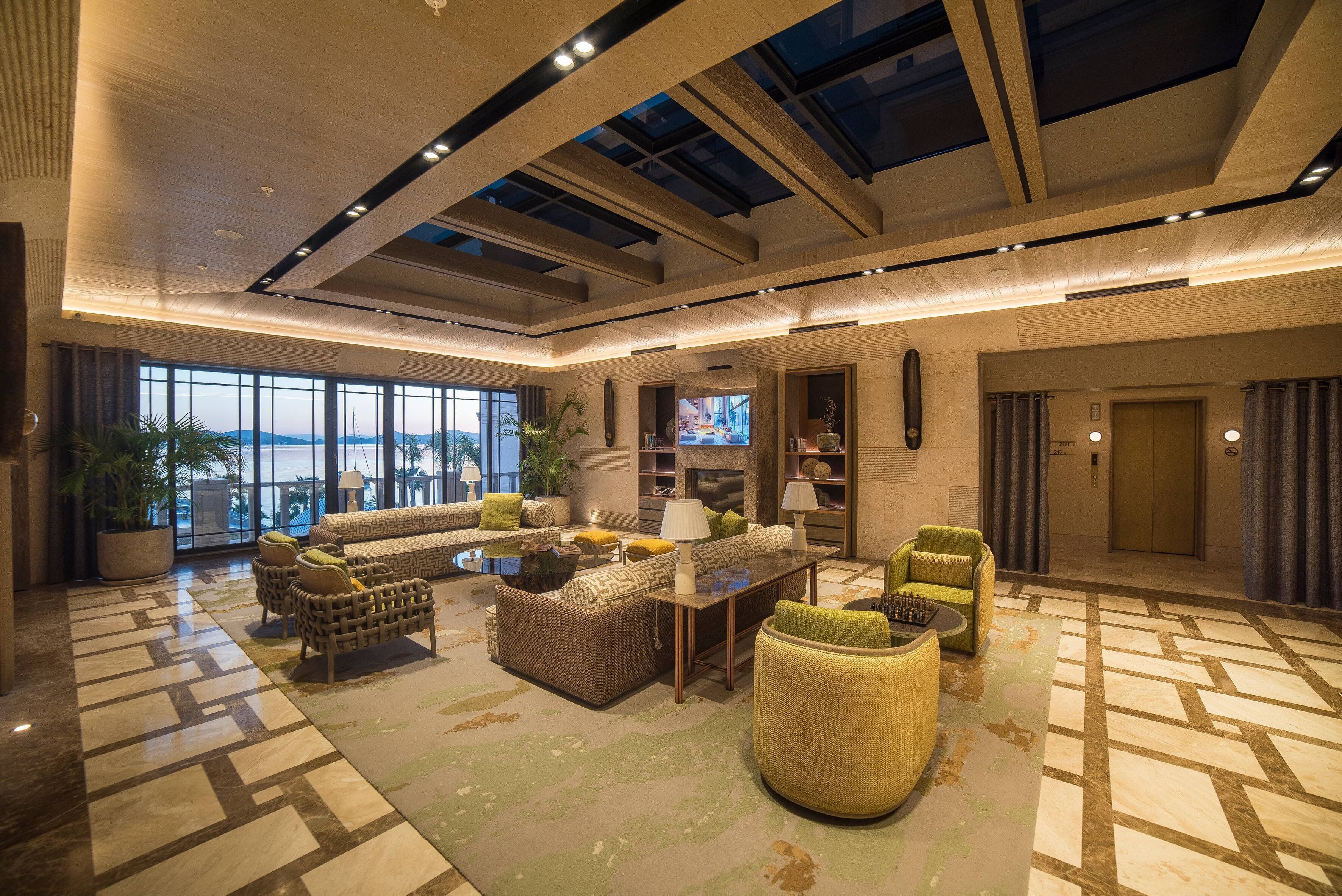A spacious lobby with a high ceiling, large windows, and a modern interior design.