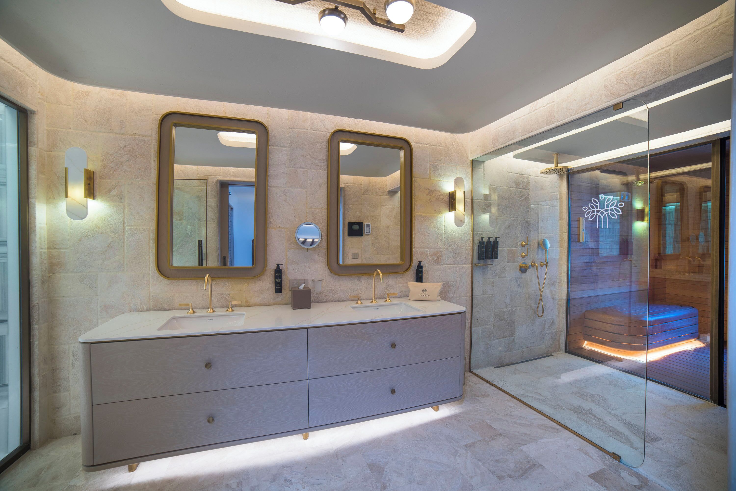 Une salle de bain moderne dotée d’un grand meuble-lavabo, de deux miroirs et d’une cabine de douche en verre.