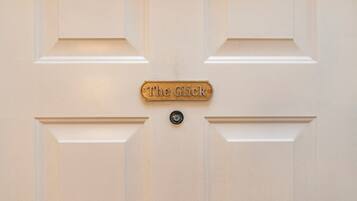 En dør med en messingplade hvorpå der står "The Glick" og en rund dørhåndtag.