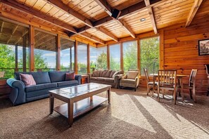 A spacious living area with a wooden ceiling, large windows, and a mix of sofas and chairs. - 7BR w/Incredible Views! Hot Tub*Game Room*Resort (Sevierville)
