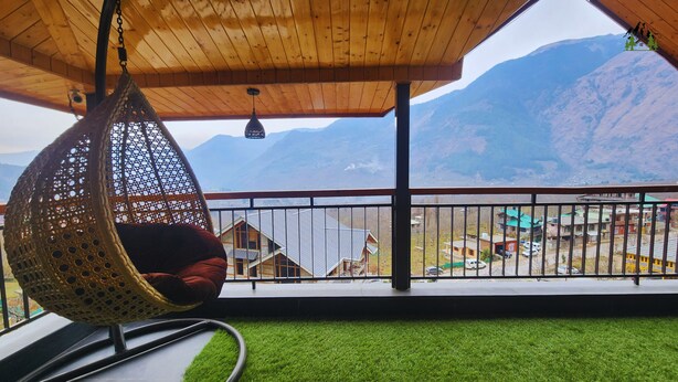 A hanging chair with a view of a mountain landscape. - La Cedar Villa by Staycation (Manali)