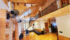A spacious loft-style room with a wooden floor, a staircase, and a balcony. - La Cedar Villa by Staycation (Manali)