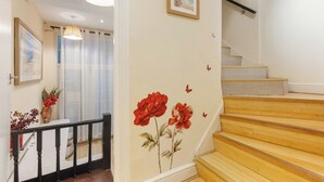 Una escalera con escalones de madera y una pared decorada con motivos florales y mariposas.