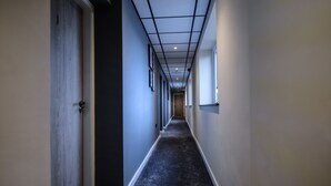 A narrow hallway with a carpeted floor, a ceiling with recessed lighting, and doors on both sides. - Ladywell House (Birmingham)