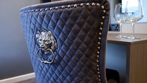 A chair with a quilted backrest and a lion-shaped metal ornament. - Ladywell House (Birmingham)