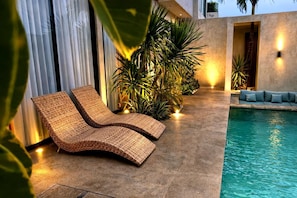 A poolside area with wicker lounge chairs, a concrete floor, and a pool. - Industrial Style 2 Bedroom Villa with Private Pool in Pererenan (Badung Regency)