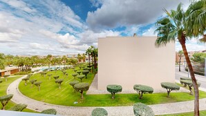 A landscaped area with a swimming pool, neatly trimmed hedges, and palm trees. - Herdade dos Salgados, T2 12C_2A, Vila das Lagoas (Albufeira)
