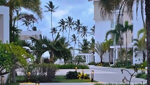 Un camino bordeado de palmeras y un edificio de diseño moderno.